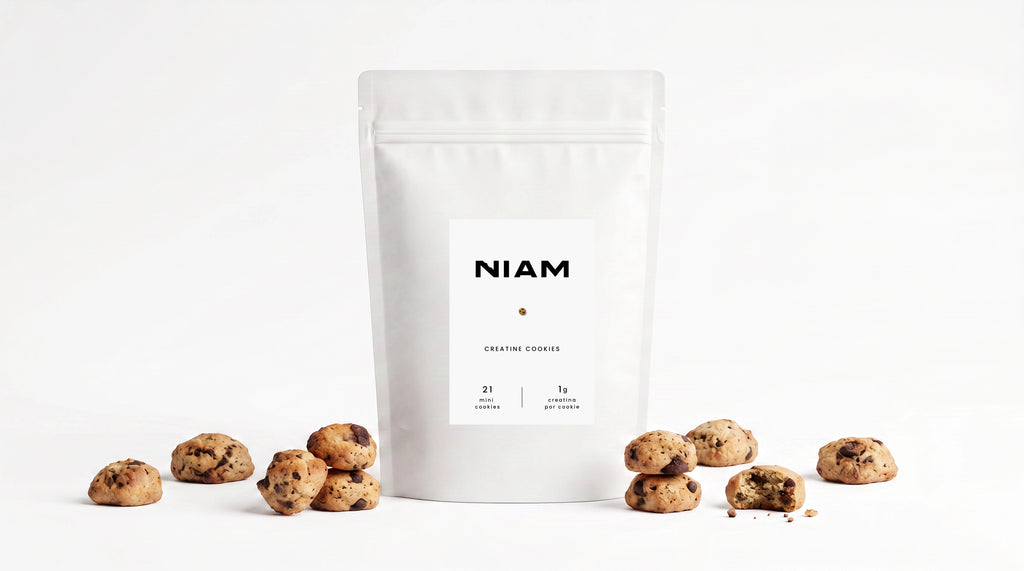 Bolsa de NIAM Creatine rodeada de mini cookies sobre fondo blanco.