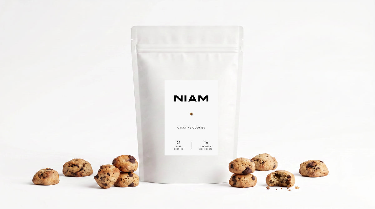 Bolsa de NIAM Creatine rodeada de mini cookies sobre fondo blanco.