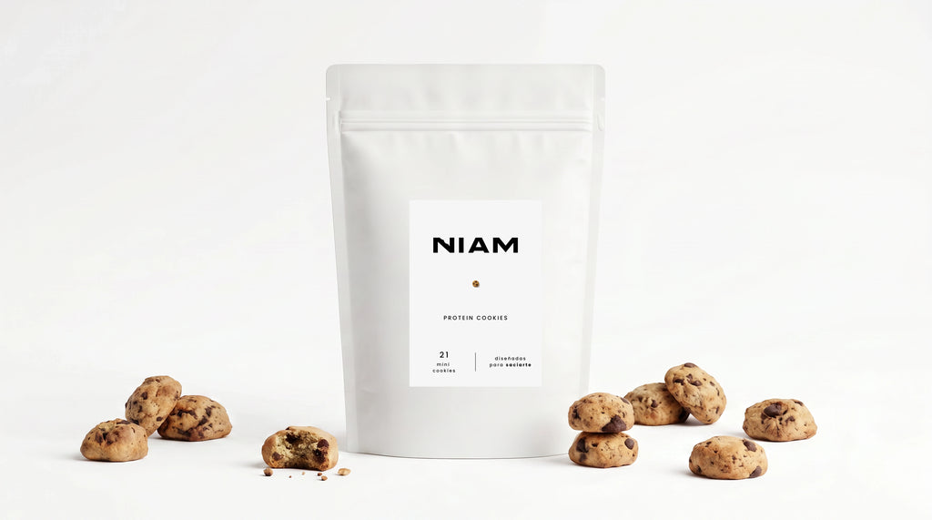 Bolsa de NIAM Protein rodeada de mini cookies sobre fondo blanco.